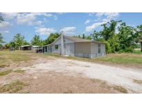 Charming single-story home featuring a gravel driveway and well-lit, welcoming entrance at 32811 County Road 473, Leesburg, FL 34788