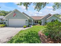 Charming single-story home featuring a well-manicured lawn and attached two-car garage at 35 China Moon Dr, Ormond Beach, FL 32174