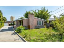 Charming single story home featuring stone accents, a brick chimney and mature landscaping at 355 Hartford Ave, Daytona Beach, FL 32118