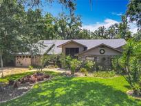 Charming single-story home boasts a well-manicured lawn, lush landscaping, and a brick facade at 4073 N Chinook Ln, Ormond Beach, FL 32174