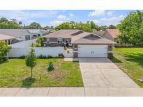 Charming single-story home featuring a two-car garage, well-manicured lawn, and white picket fence at 5478 Landis Ave, Port Orange, FL 32127