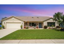Charming single-story home featuring a manicured lawn, inviting front porch, and attached two-car garage at 928 Chickadee Dr, Port Orange, FL 32127