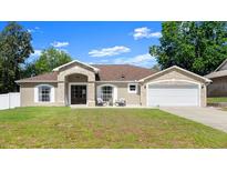 Charming single-story home with stone accents, inviting front porch, and well-manicured lawn at 2600 Scottville Ave, Deltona, FL 32725