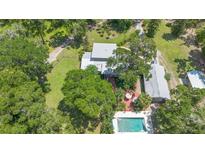 Sprawling estate boasts a large pool and patio area surrounded by mature trees and lush landscaping at 1056 Reynolds Rd, De Leon Springs, FL 32130