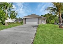 Charming single-story home featuring an attached two-car garage and a well-manicured lawn at 1226 North St, Daytona Beach, FL 32114