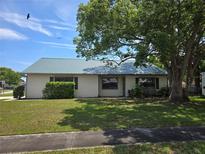 Charming single-story home with a well-maintained lawn, mature tree, and durable metal roof at 1272 Robbin Dr, Port Orange, FL 32129