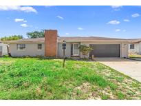 Charming single-story home featuring an attached garage and brick chimney, perfect for comfortable living at 1483 Meadowlark Dr, Deltona, FL 32725
