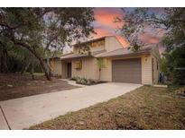 Charming two-story home featuring an attached garage and mature trees in a serene setting at 241 Bayou Vista St, Debary, FL 32713