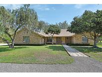 Charming single-story brick home with a well-manicured lawn, mature trees, and a stone pathway to the front door at 2699 Audubon Ave, Deland, FL 32720