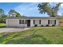 Charming single-story home featuring a well-maintained lawn, stone walkway, and attached garage at 272 Sunrise Blvd, Debary, FL 32713