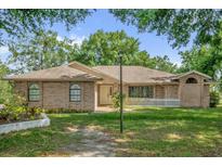 Charming brick home features a well-manicured lawn and inviting front entrance at 2885 Newmark Dr, Deltona, FL 32738