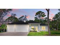 Charming single-story home featuring a three-car garage and lush landscaping, perfect for suburban living at 2894 Hardy Ave, New Smyrna Beach, FL 32168