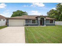 Charming single-story home featuring a two-car garage, well-maintained lawn, and inviting curb appeal at 37 Naranja Rd, Debary, FL 32713
