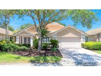 Charming single-story home featuring a neutral color palette, a two-car garage and mature landscaping at 438 Harbour Town Ln, Ormond Beach, FL 32174
