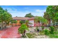 Single-story home featuring a red, paved driveway and tropical landscaping at 558 Tulane Dr, Altamonte Springs, FL 32714