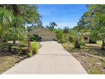 Charming single-story home with lush tropical landscaping and a long driveway at 5635 Burts Park Rd, De Leon Springs, FL 32130