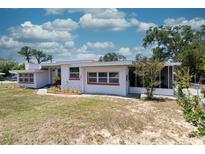 Charming single-story home with white exterior and red trim, surrounded by a well-manicured lawn at 601 Berkshire Rd, Daytona Beach, FL 32114