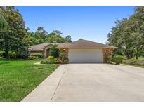 Charming single-story brick home with a spacious two-car garage and well-manicured lawn at 980 Marjorie Rawlings Dr, Deland, FL 32720
