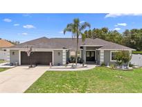 Charming single-story home with a well-maintained front yard and a basketball hoop over the garage at 10800 Crescent Ridge Loop, Clermont, FL 34711
