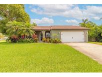 Charming single-story home with well-maintained lawn, colorful landscaping and two car garage at 1166 Tracy Dr, Port Orange, FL 32129