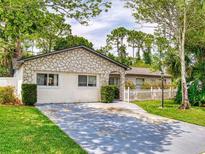 Charming one-story home with a stone exterior and a well-maintained front yard with a concrete driveway at 1229 Jeffery Dr, Port Orange, FL 32129
