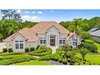 Beautifully landscaped home with a tile roof, manicured shrubs, and a double-door entrance for added curb appeal at 1324 Dovercourt Ln, Ormond Beach, FL 32174