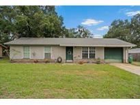 Charming single-story home with a well-maintained lawn, green door, and attached one car garage at 137 Fort Smith Blvd, Deltona, FL 32738