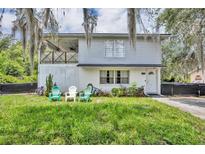 Two story home with a balcony, landscaped lawn, and outdoor seating in the front yard at 1398 5Th Ave, Deland, FL 32724