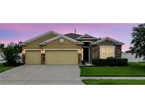 Charming single-Gathering home featuring a two-car garage, stone accents and well-manicured lawn at 1444 Daystar Ln, Deltona, FL 32725