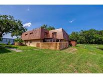 A charming home featuring a unique roofline, fenced yard, and lush green lawn at 152 Sweetgum Ln, Port Orange, FL 32129