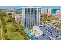 Stunning aerial view of a high-rise condo, golf course, swimming pool, parking, and beach access at 2 Oceans West Blvd # 305, Daytona Beach, FL 32118
