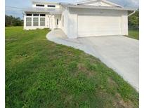 Charming home with a large two car garage and lush front yard with a curved sidewalk leading to the front door at 2689 Courtland Blvd, Deltona, FL 32738