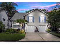 Charming two-story home featuring a two-car garage and lush landscaping with palm trees at 275 Bayou Cir, Debary, FL 32713