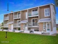 A well-maintained building with multiple units, featuring balconies and green space at 2898 Ocean Shore Blvd # 603, Ormond Beach, FL 32176