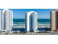 Oceanfront condo building featuring white balconies, direct beach access, and convenient parking at 3047 S Atlantic Ave # 1805, Daytona Beach, FL 32118