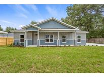 Charming, newly built single-Gathering home featuring a covered front porch, green lawn, and modern two-tone exterior at 349 Baker Ave, Lake Helen, FL 32744