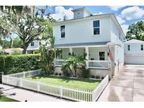 Charming two-story home with a well-manicured lawn, white picket fence, and inviting front porch at 417 S Palmetto Ave, Daytona Beach, FL 32114