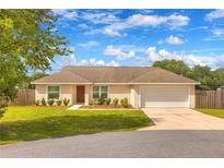 Charming single-story home boasts a well-manicured lawn, attached two-car garage, and neutral color palette at 6 Laurel Pass Ct, Ocala, FL 34480