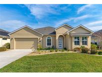 Charming one-story home featuring a well-manicured lawn and a two-car garage, exuding curb appeal at 6871 Forkmead Ln, Port Orange, FL 32128