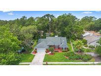 Aerial shot of the red brick home featuring a lush green lawn and mature trees surrounding the property at 802 Royal Oak Ct, Deland, FL 32724