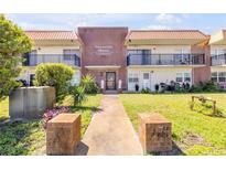 Inviting condo complex with manicured lawn, mature trees, and prominent signage at 10 Lynnhurst Dr # 1050, Ormond Beach, FL 32176