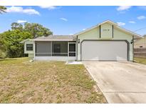 Charming single-story home featuring a two-car garage and a screened-in porch at 1018 E Gaucho Cir, Deltona, FL 32725