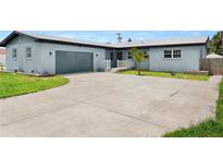 Charming single-story home featuring a spacious driveway and well-maintained front yard with a beautiful tree at 1027 Bel Aire Dr, Daytona Beach, FL 32118