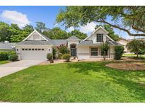 Charming single-Gathering home featuring lush lawn, mature trees, and well-maintained landscaping at 1205 Weeping Willow Dr, Deland, FL 32724
