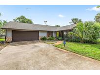 Charming single-story home with a two-car garage, mature landscaping and a well maintained lawn at 1411 N Beach St, Ormond Beach, FL 32174