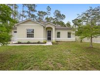 Charming single-story home featuring a well-manicured lawn and a welcoming front entrance and a two-car garage at 1683 10Th Ave, Deland, FL 32724