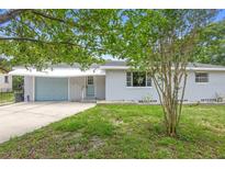 Charming single-story home with a well-maintained front lawn and attached garage at 220 N Julia Ave, Deland, FL 32720