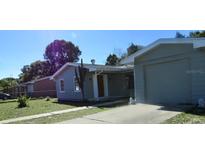 Charming single-story home featuring attached garage, front yard and mature trees at 2366 Florida Dr, Deltona, FL 32738