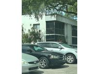 Building exterior with screen patios, greenery, and parking lot with multiple cars at 2565 Oak Park Way # 213, Orlando, FL 32822