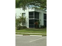 A two-story condo with screened balconies and lush green lawn and landscaping at 2565 Oak Park Way # 213, Orlando, FL 32822